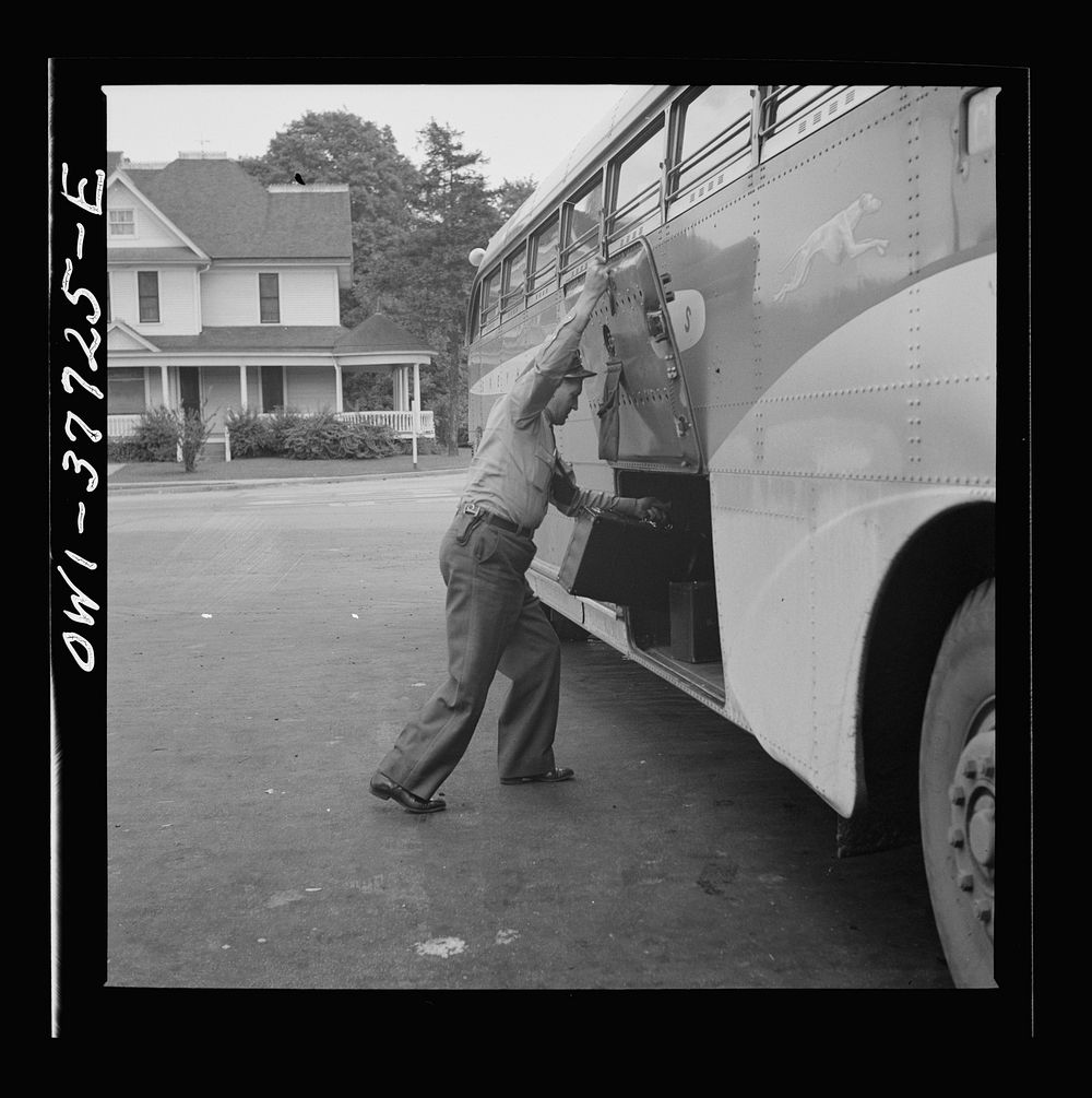 A Greyhound bus driver loading baggage at a small town between Chicago, Illinois and Cincinnati, Ohio. Sourced from the…