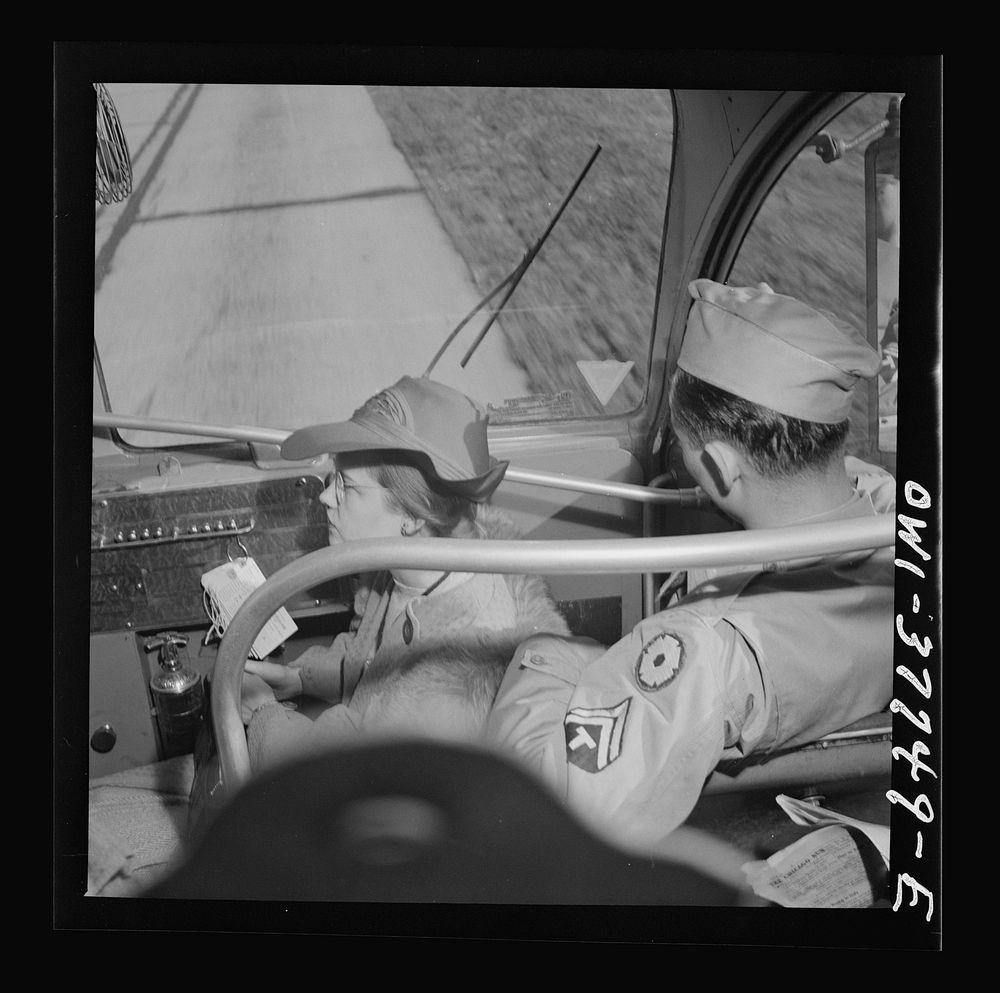 A girl riding in the jump seat which was originally meant for the porter, because standing room in the aisles is taken on a…