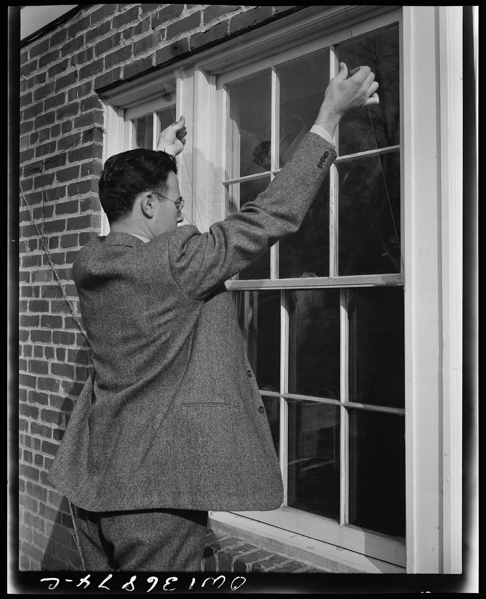 Washington, D.C. Installing a "Victory" storm pane, or extra pane of glass on a home window as a war-time fuel conservation…