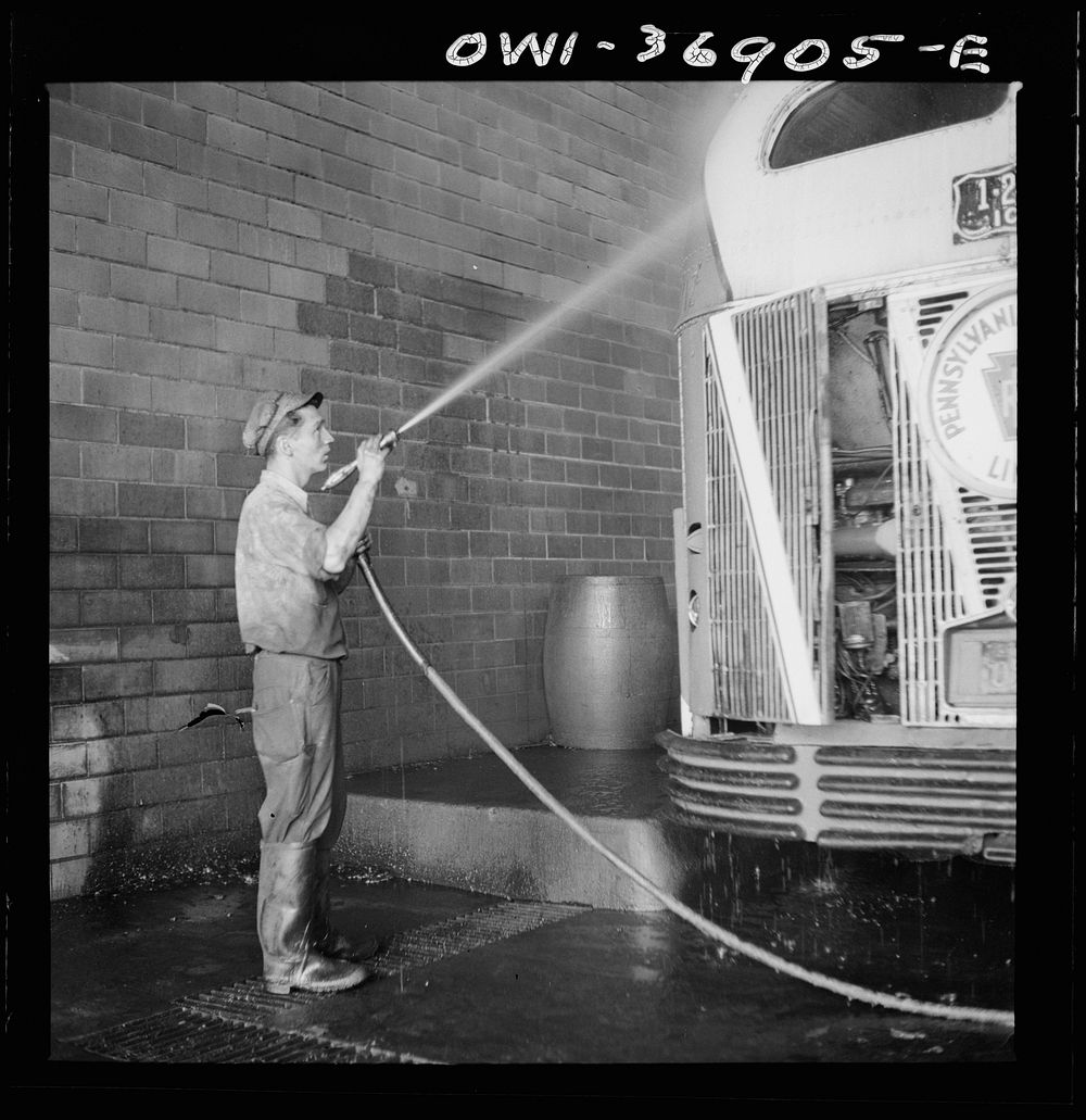Pittsburgh, Pennsylvania. A bus serviceman washing a bus which has just come in from a run in the Greyhound garage. Sourced…