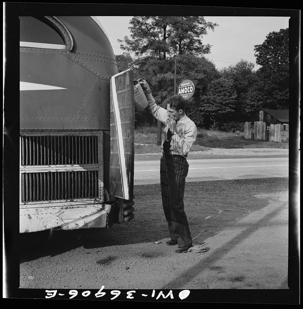 [Untitled photo, possibly related to: A Greyhound bus that has been stopped while the driver fills the water tank at a gas…