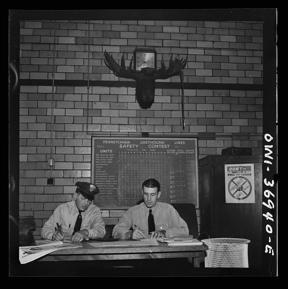 Pittsburgh, Pennsylvania. Greyhound bus drivers writing out trip reports in the garage. Sourced from the Library of Congress.