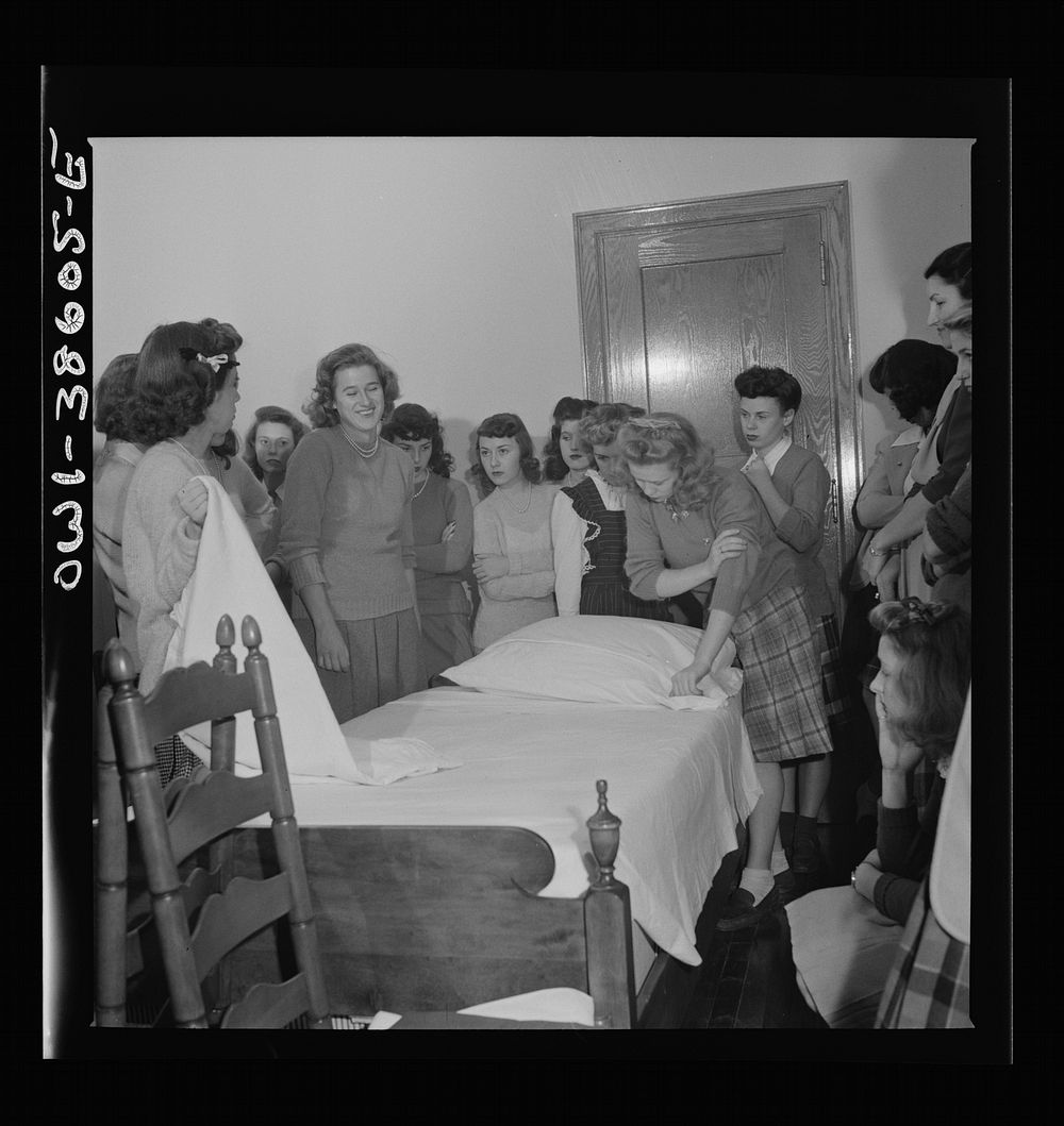 Washington, D.C. Home management students at Woodrow Wilson High School giving a demonstration in bedmaking. There is a…