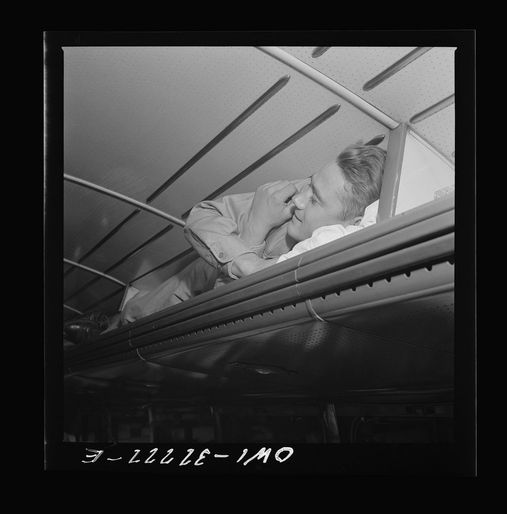 [Untitled photo, possibly related to: A soldier sleeping in the baggage rack on a Greyhound bus going from Cincinnati, Ohio…