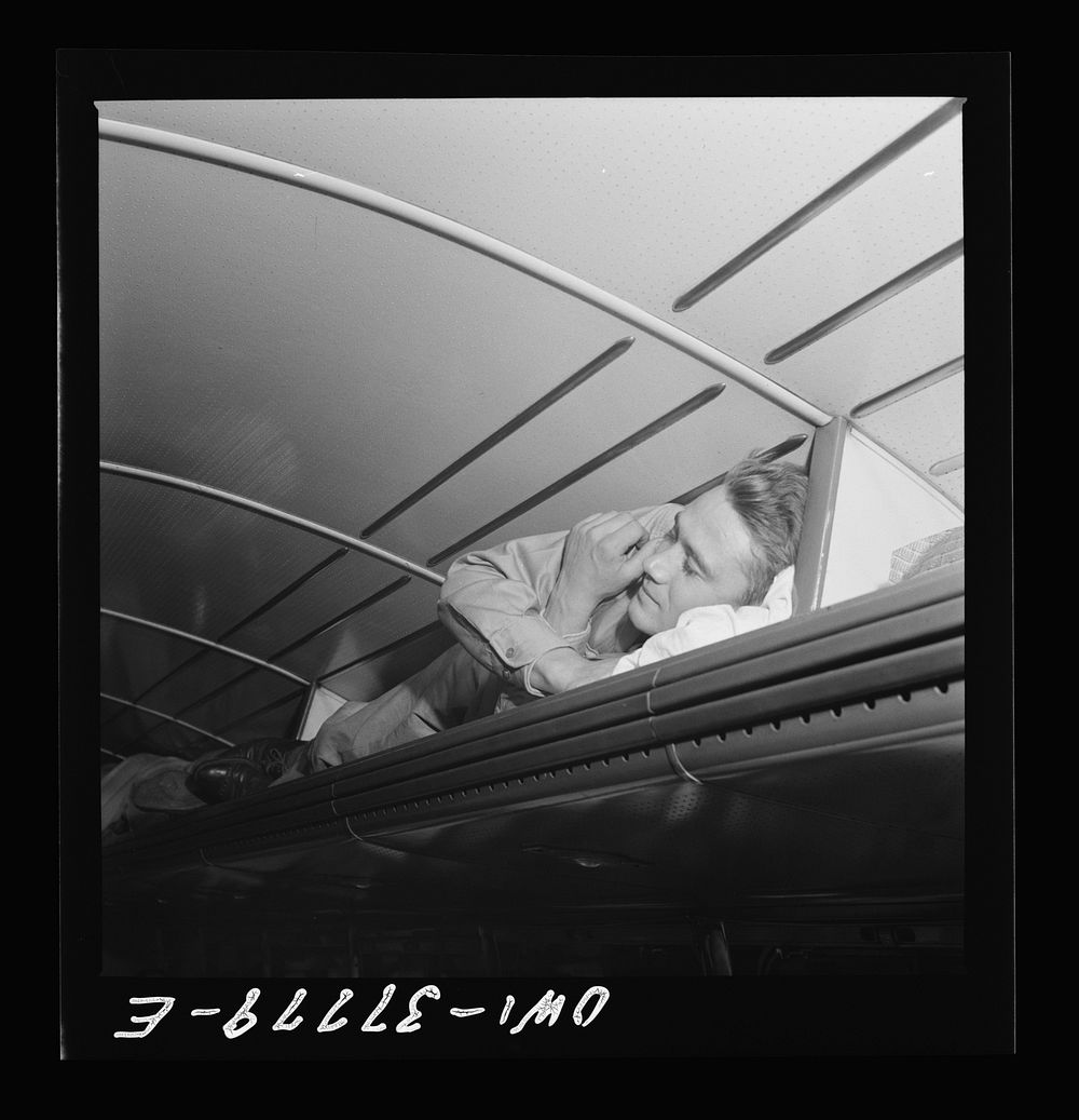 A soldier sleeping in the baggage rack on a Greyhound bus going from Cincinnati, Ohio to Louisville, Kentucky. Sourced from…