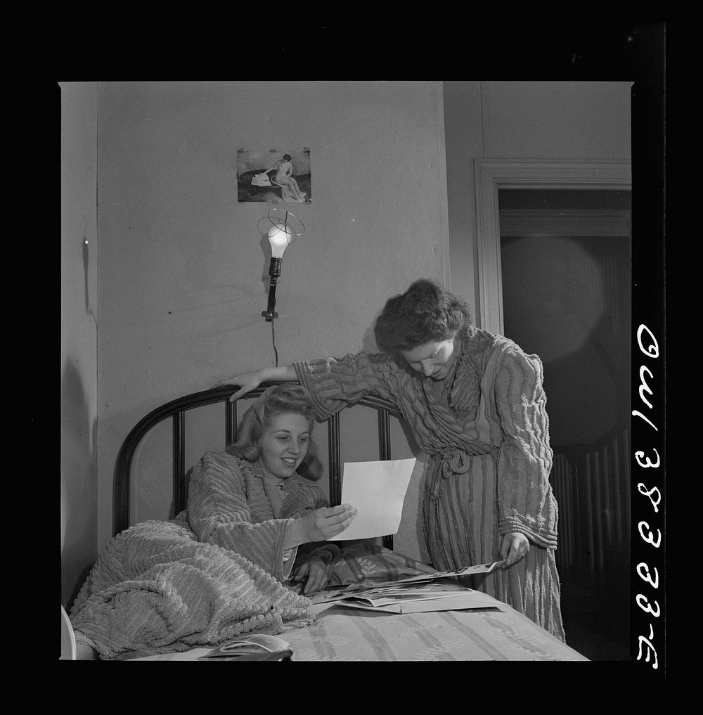 Washington, D.C. Two girls looking at pictures in their room in a boardinghouse. Sourced from the Library of Congress.