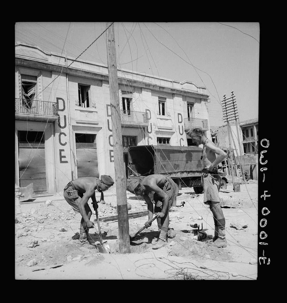 British and Italian soldiers work stripped to the waist in an effort to return Sicilian communication facilities to normal.…