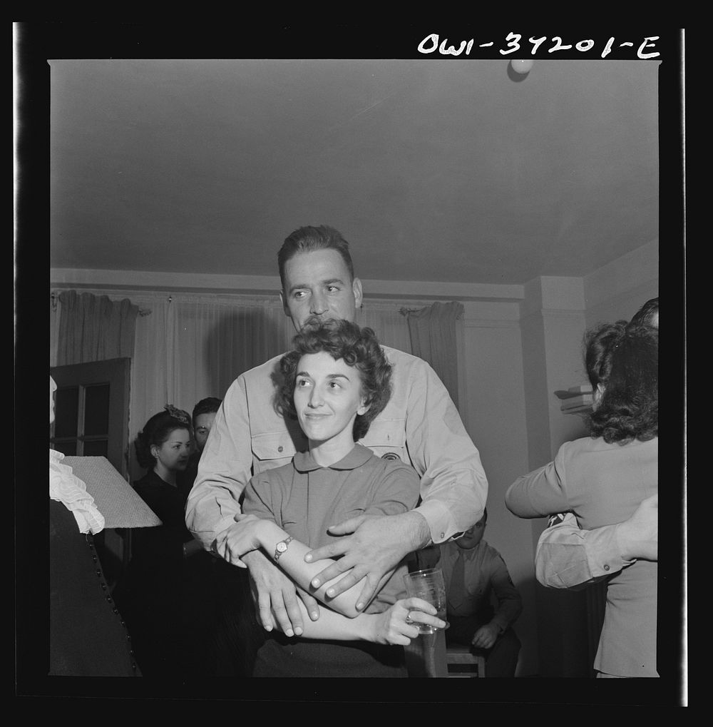 [Untitled photo, possibly related to: Washington, D.C. Serviceman and a girl looking at pictures at a party]. Sourced from…
