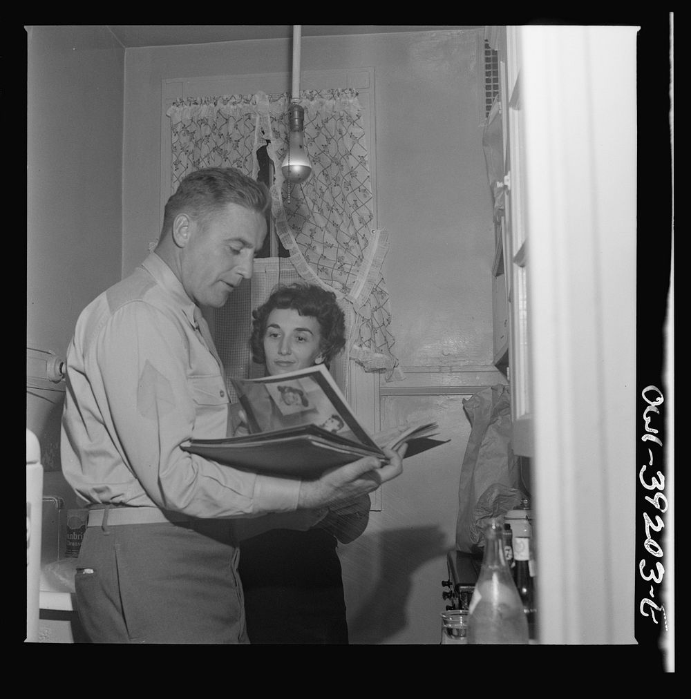 Washington, D.C. Serviceman and a girl looking at pictures at a party. Sourced from the Library of Congress.
