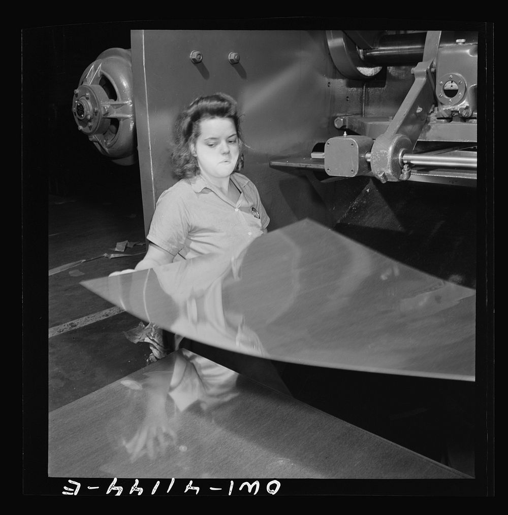 Boeing aircraft plant, Seattle, Washington. Production of B-17F (Flying Fortress) bombing planes. A sheet metal worker.…