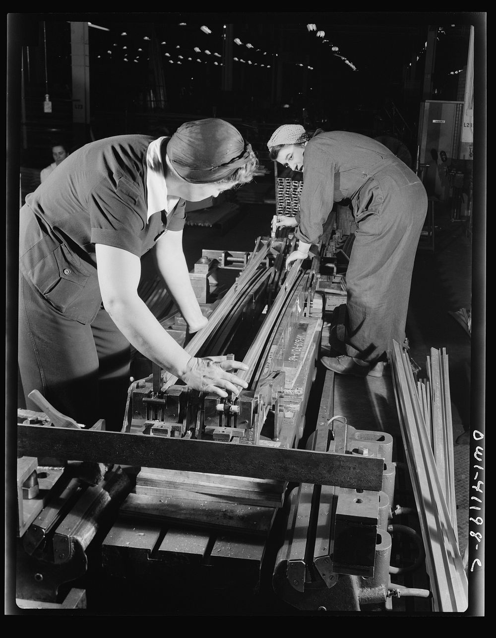 Boeing aircraft plant, Seattle, Washington. Production of B-17 (Flying Fortress) bombing planes. Two women working on a…