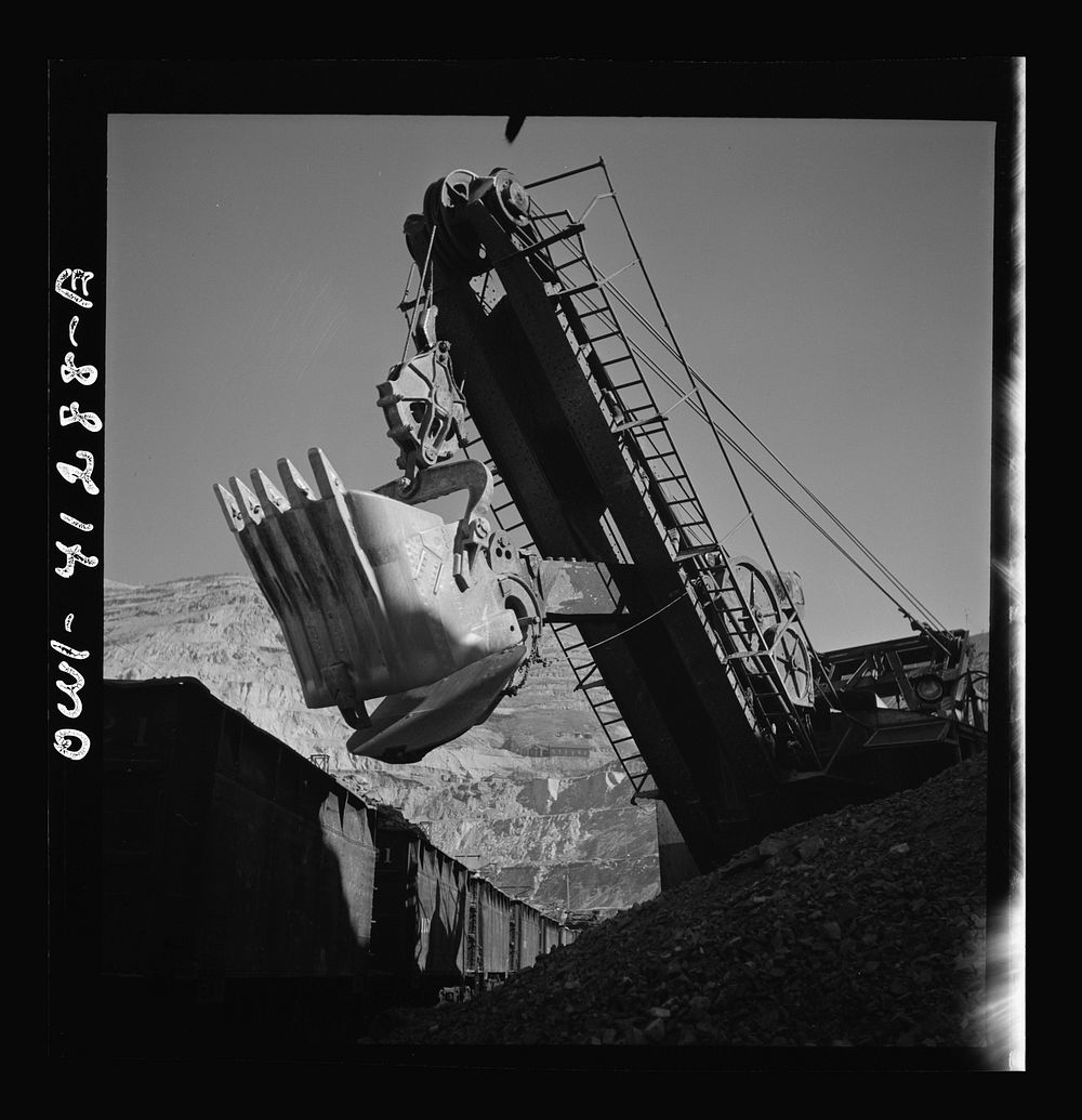Bingham Canyon, Utah. Huge dipper of a power shovel loading ore into a car at a mine of the Utah Copper Company. Sourced…