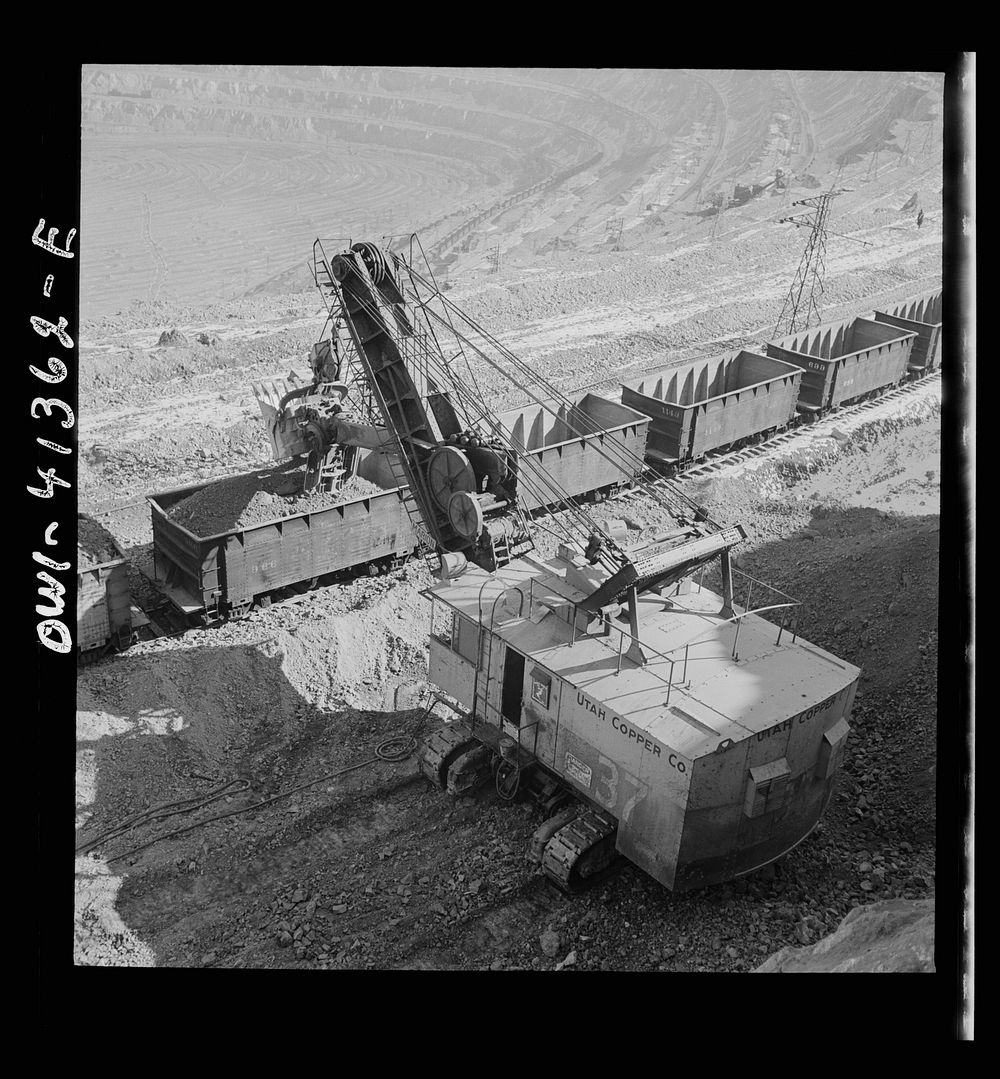 Bingham Canyon, Utah. Loading ore into car with a power shovel at an open-pit mine of the Utah Copper Company. Sourced from…