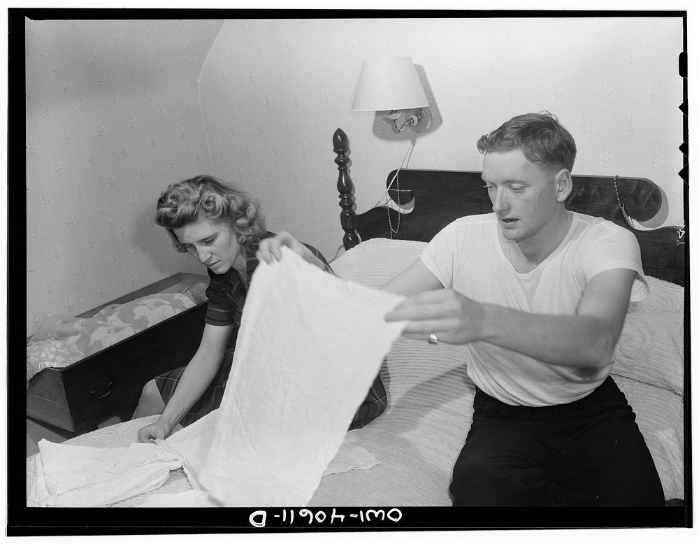 Washington, D.C. In the evening, Hugh Massman and his wife fold diapers. Joey's bureau drawer crib is moved to the side of…