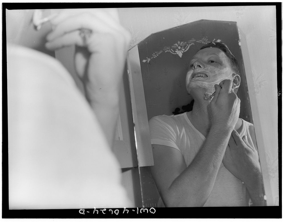 Washington, D.C. Hugh Massman, a second class petty officer who is studying in Washington, shaving. Sourced from the Library…