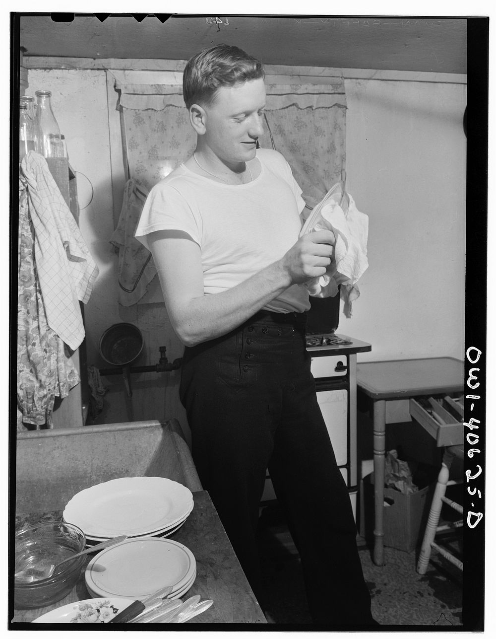 Washington, D.C. After dinner, Hugh Massman, a second class petty officer who is studying in Washington, does the dishes…