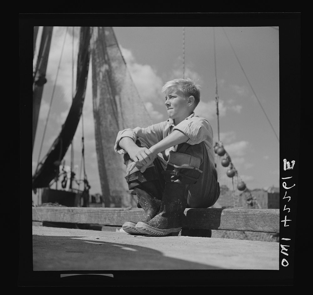 Gloucester, Massachusetts. A young boy, probably a fisherman of tomorrow, because many of the boys will follow their fathers…