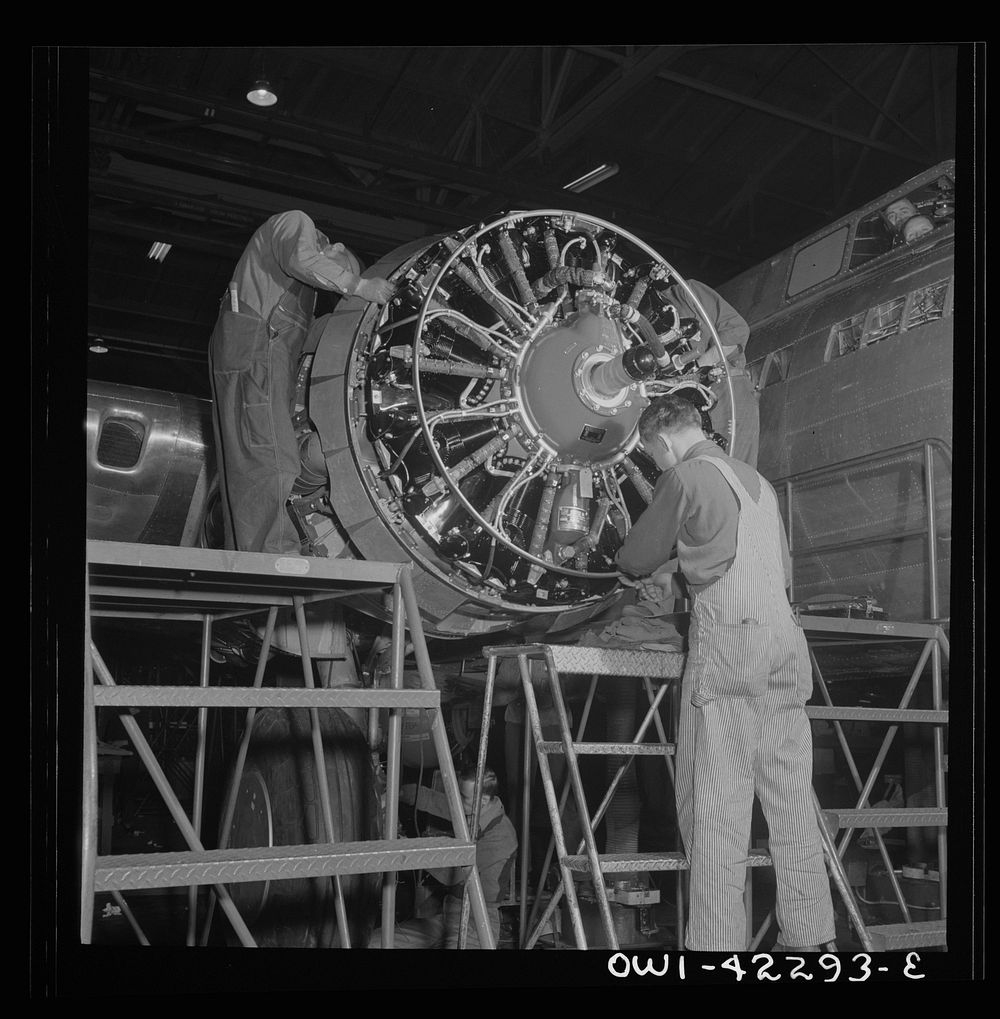 Seattle, Washington. Boeing aircraft plant. Production of B-17F (Flying Fortress) bombing planes. Workers assembling a motor…