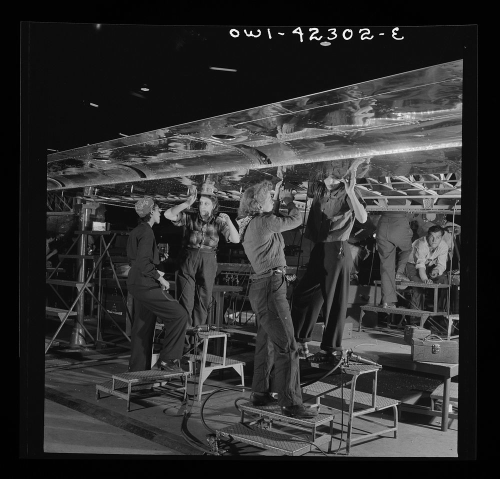 Seattle, Washington. Boeing aircraft plant. Production of B-17F (Flying Fortress) bombing planes. A crew working on the…