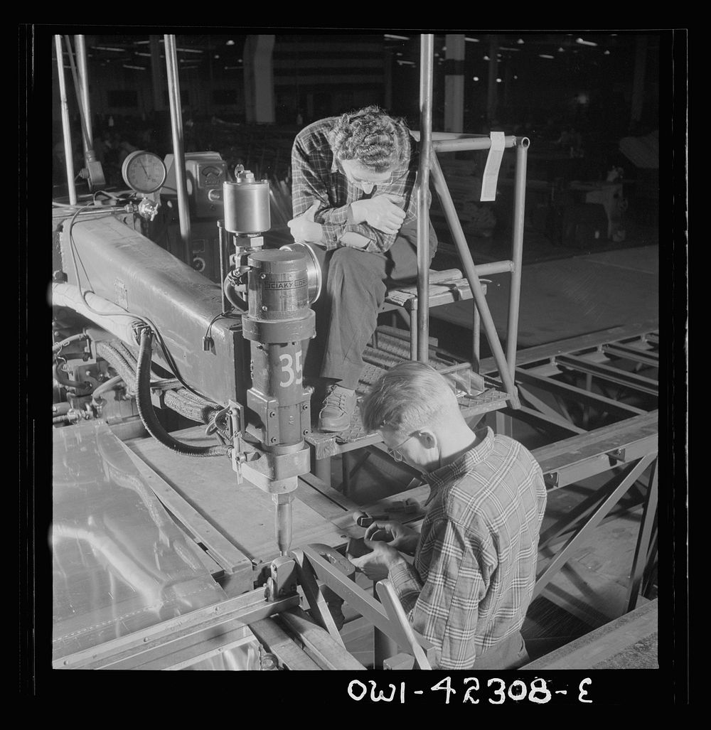 Boeing aircraft plant, Seattle, Washington. Production of B-17F (Flying Fortress) bombing planes. Spot welders. Sourced from…
