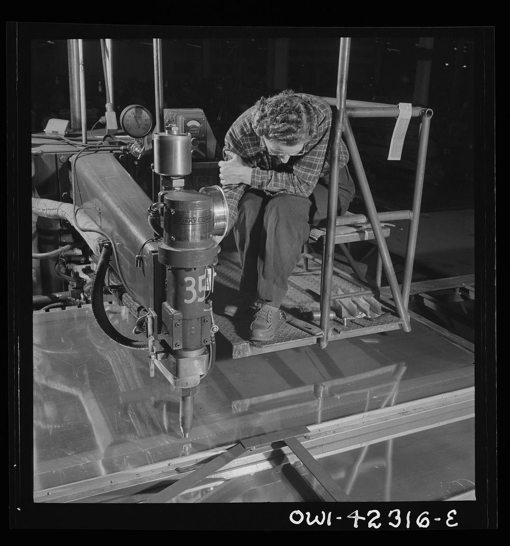 Boeing aircraft plant, Seattle, Washington. Production of B-17F (Flying Fortress) bombing planes. A spot welder. Sourced…
