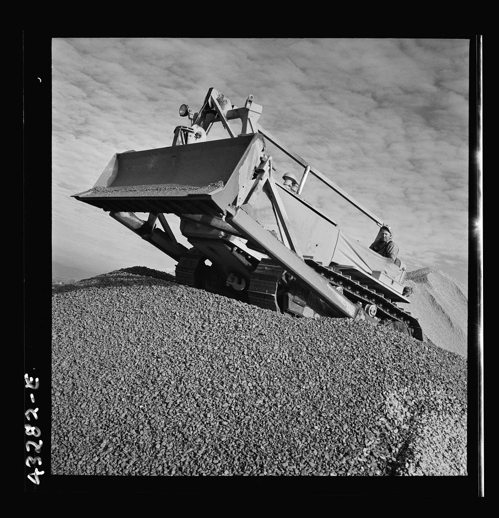 Columbia Steel Company at Geneva, Utah. Bulldozer handling gravel for concrete during the construction of a new steel mill…