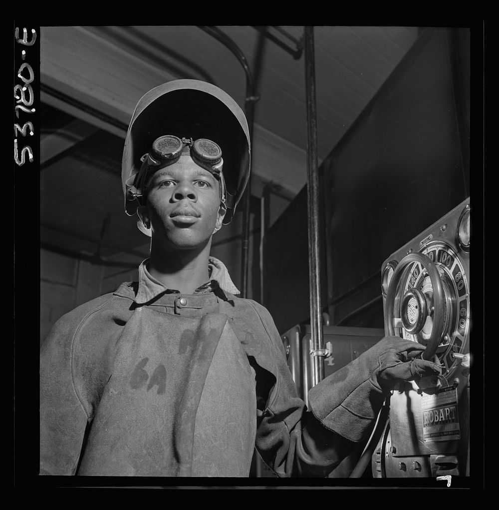 NYA (National Youth Administration) work center, Brooklyn, New York. A , who is receiving training in arc welding, adjusting…