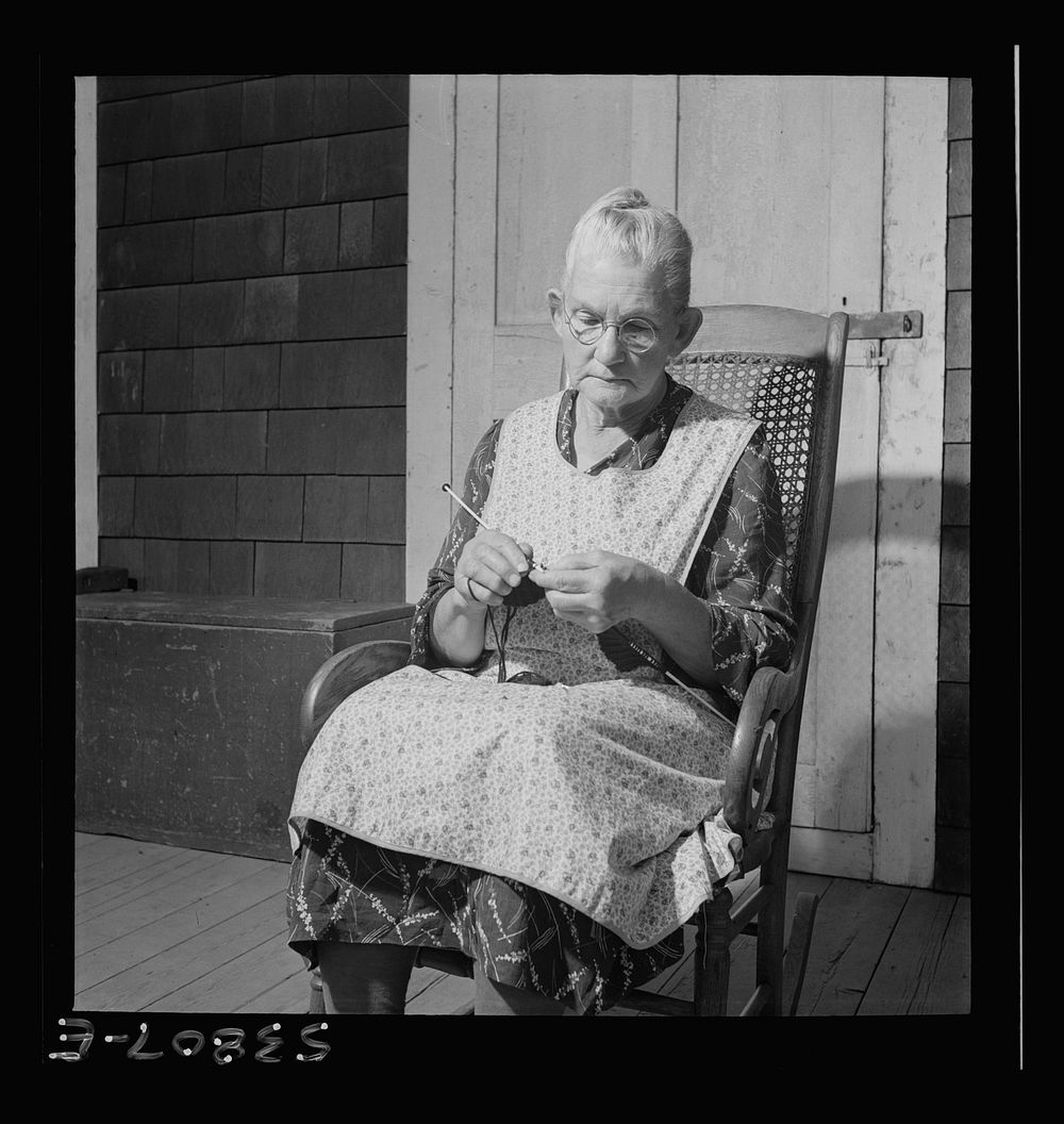 East Montpelier, Vermont. Charles Ormsbee's widowed mother, [Myrtie] Ormsbee, knitting sweaters for the Red Cross. Mr.…