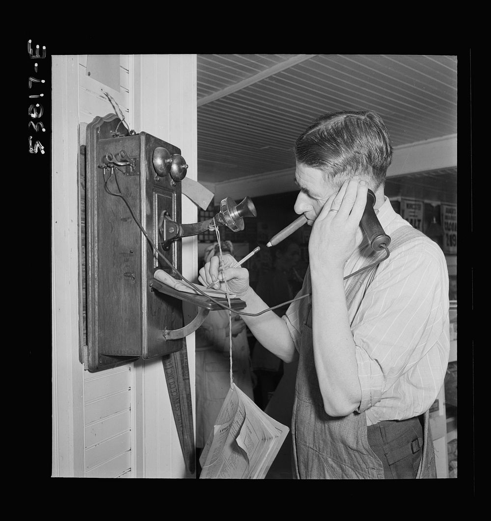 West Danville, Vermont. Mr. Hastings in his general store taking an order over the telephone. Sourced from the Library of…