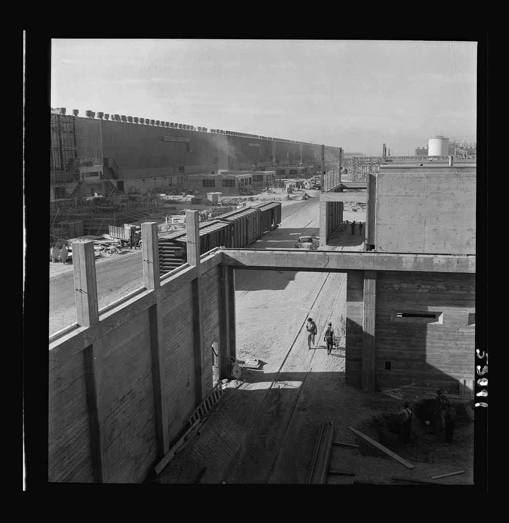 Las Vegas, Nevada. Workmen, trucks, railroad boxcars, tool sheds, and many buildings during an early construction period of…