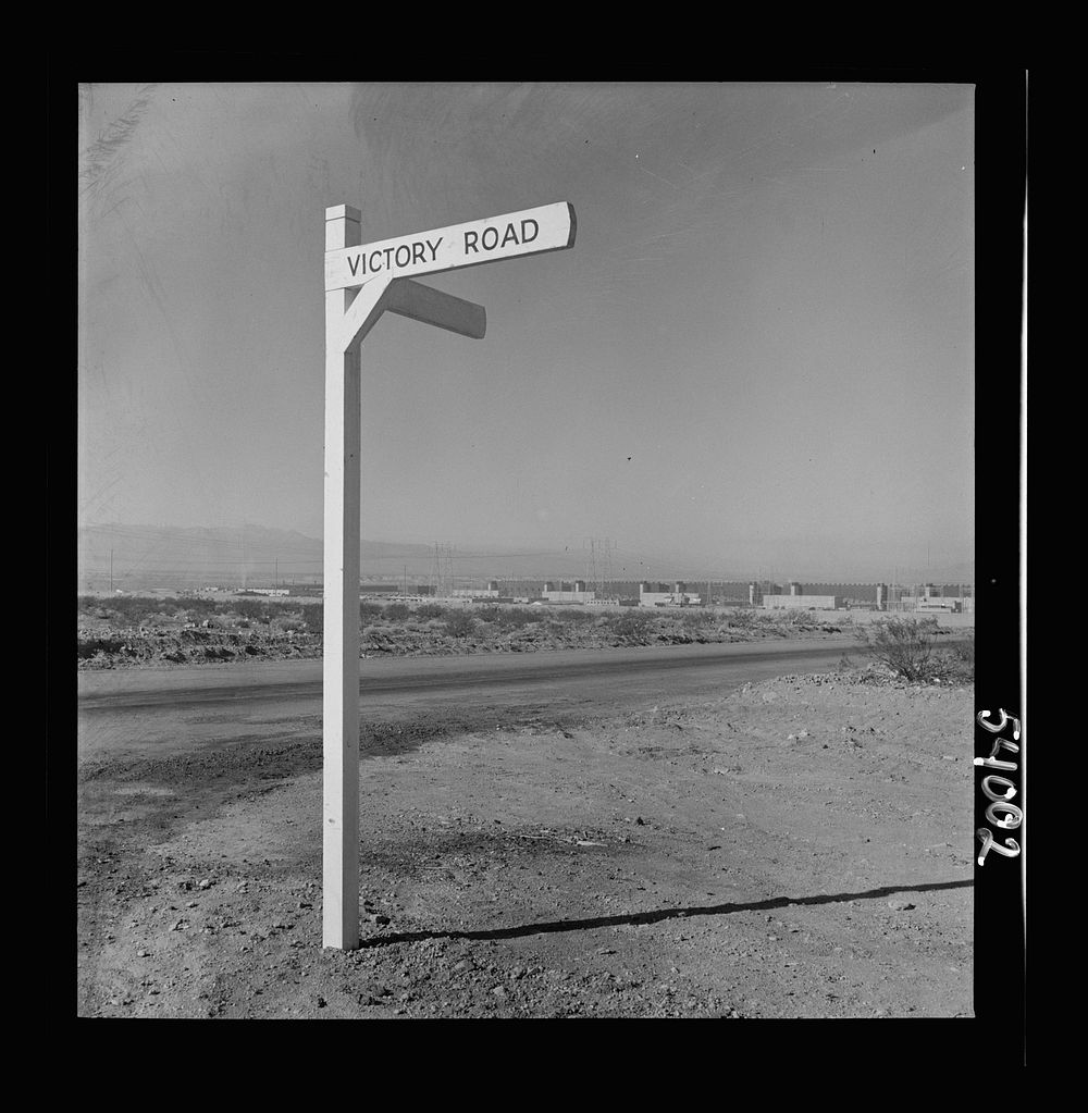 [Untitled photo, possibly related to: Las Vegas, Nevada. A crossroad sign reading "Victory Road," with buildings, storage…