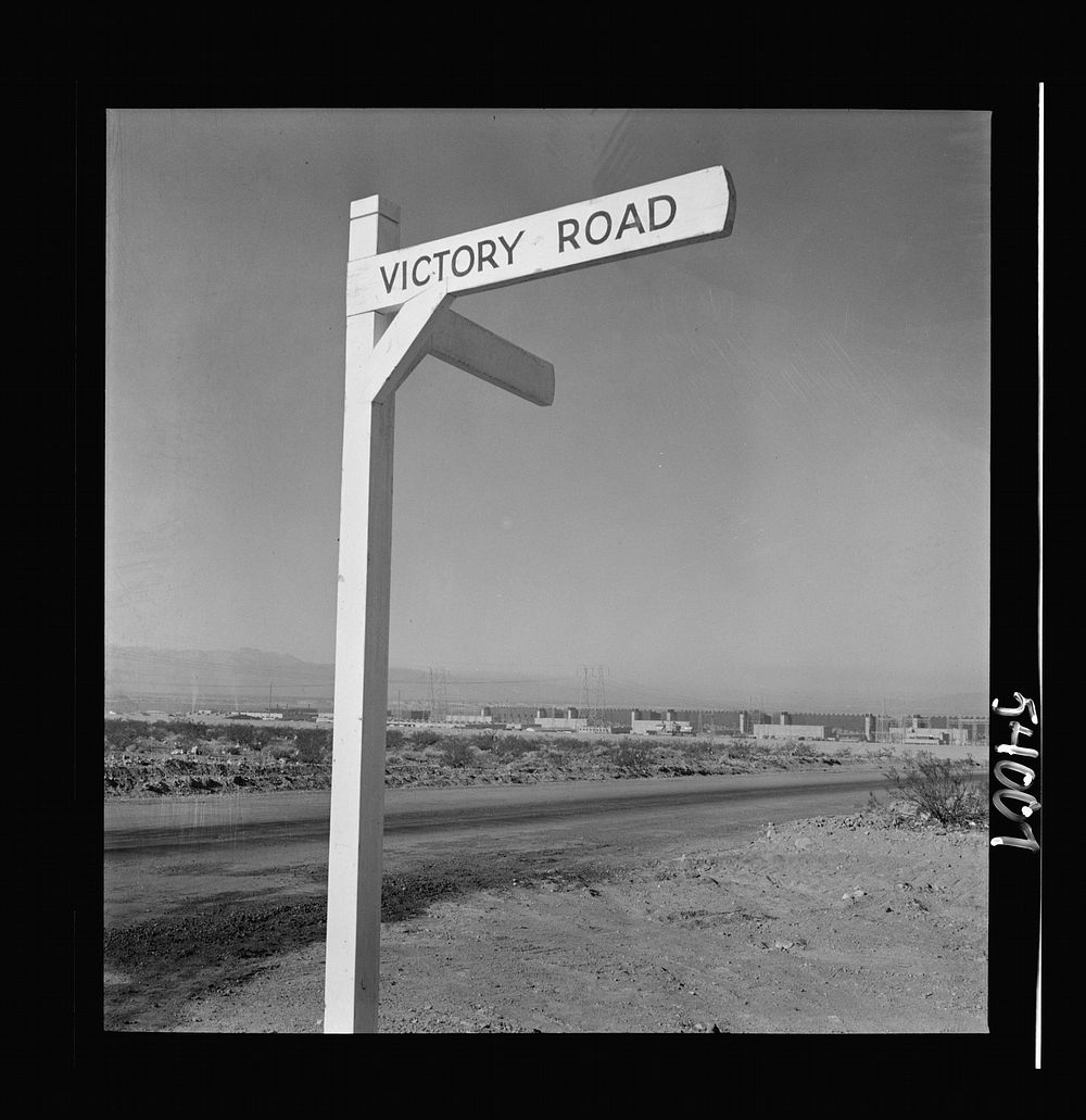 [Untitled photo, possibly related to: Las Vegas, Nevada. A crossroad sign reading "Victory Road," with buildings, storage…