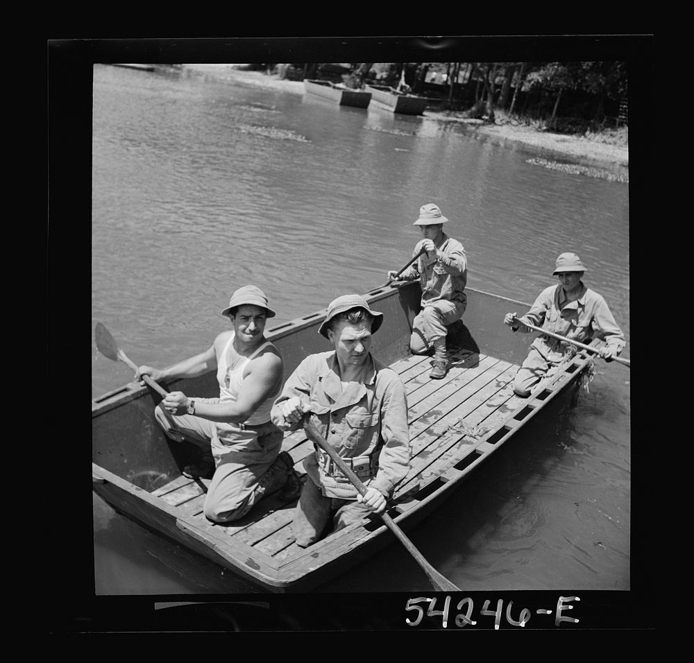 Fort Belvoir, Virginia. Four soldiers of the United States Army Engineer Corps paddling a barge, probably for the…