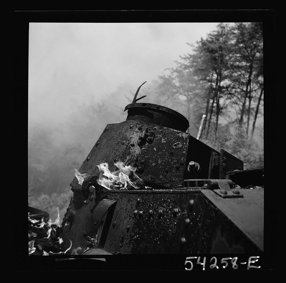 Fort Belvoir, Virginia. A burning armored tank, showing the effects of a hit by a "Molotov cocktail" grenade. Sourced from…