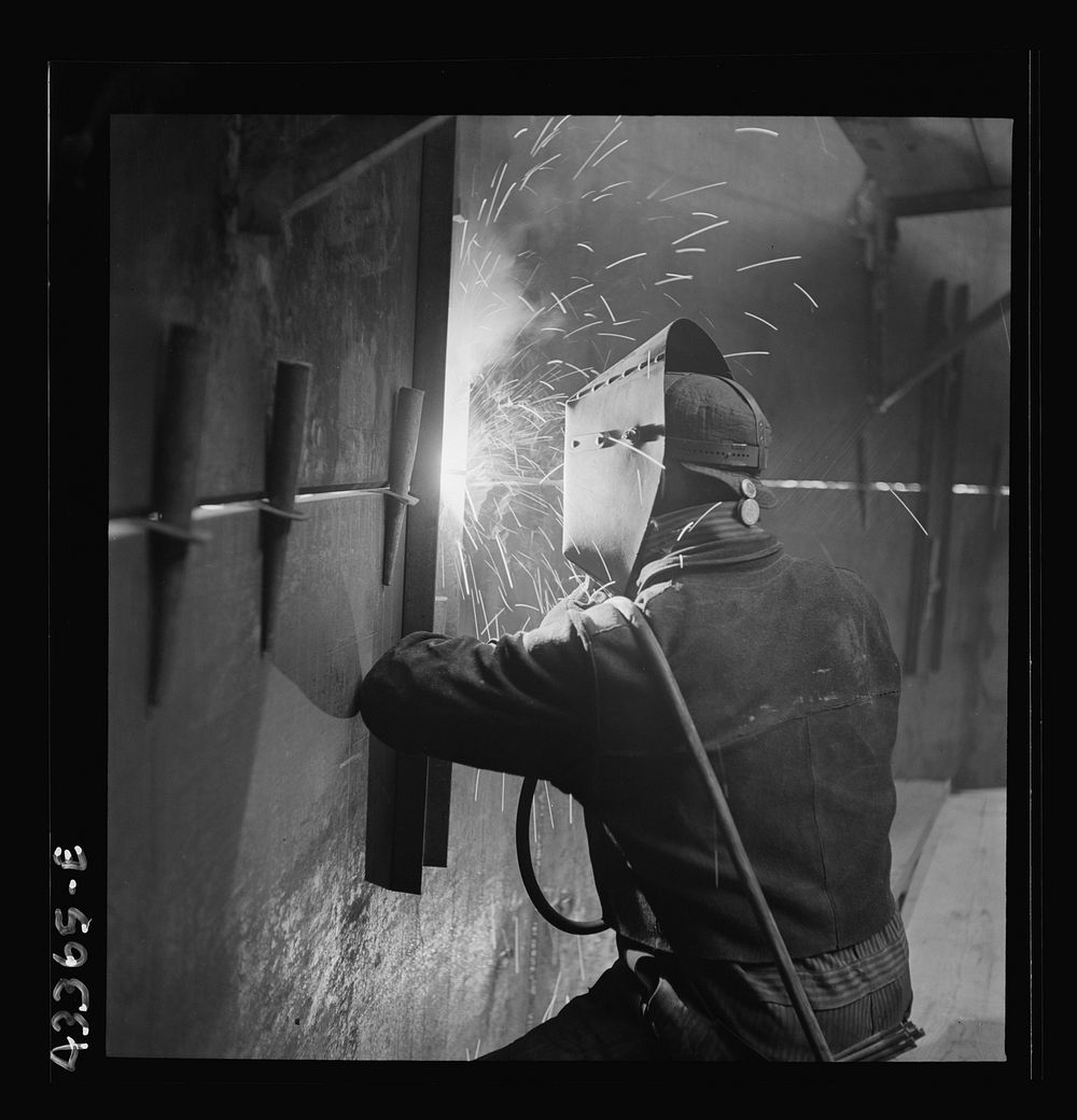 [Untitled photo, possibly related to: Columbia Steel Company at Geneva, Utah. An electric arc welder helping in the…