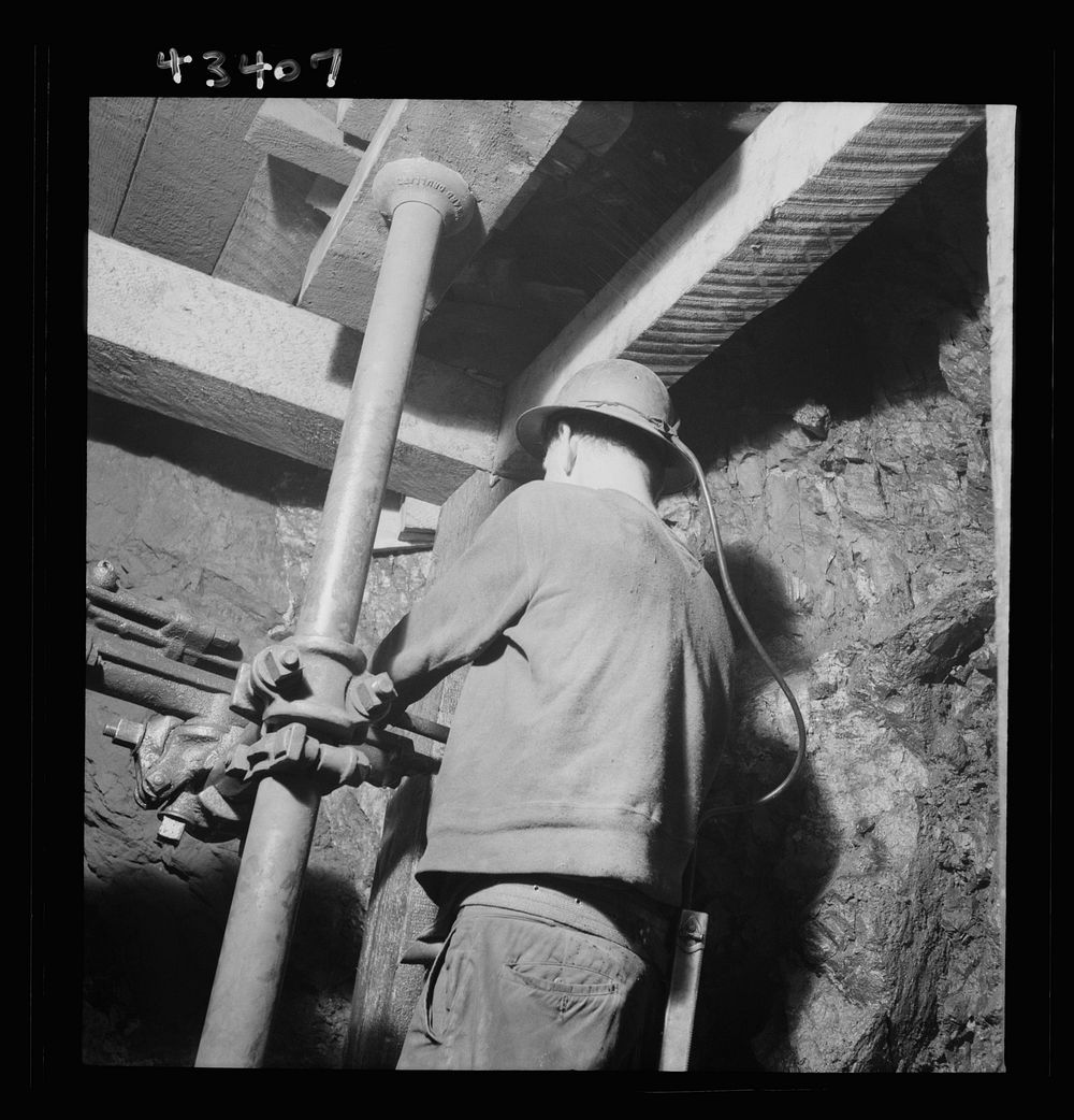 New Idria, California. Drilling blast holes with a compressed-air rock drill in one of the workings of the New Idria…