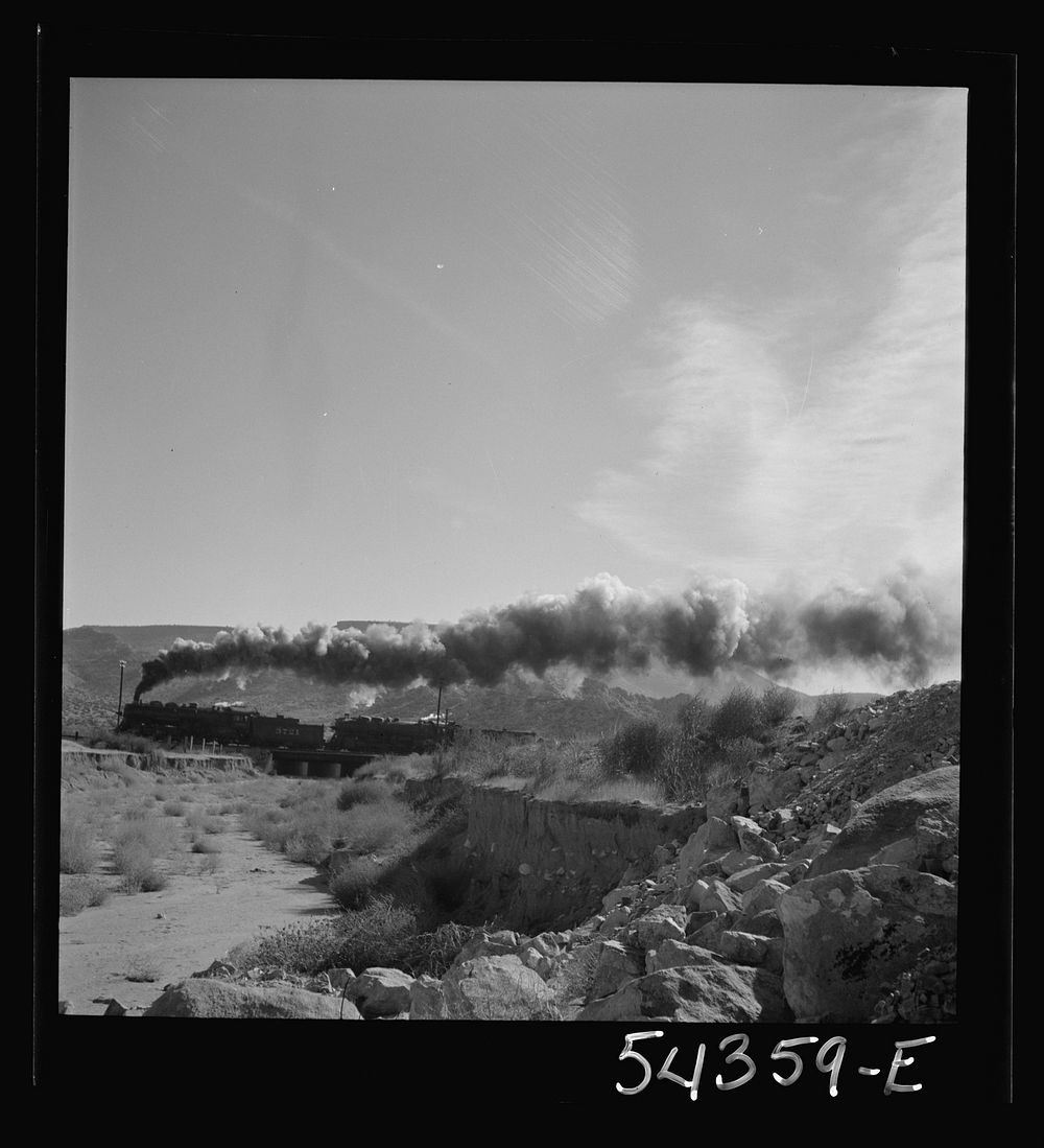 Kingman (vicinity), Arizona. A transcontinental train passing close to the tungsten recovery plant where the ore from the…