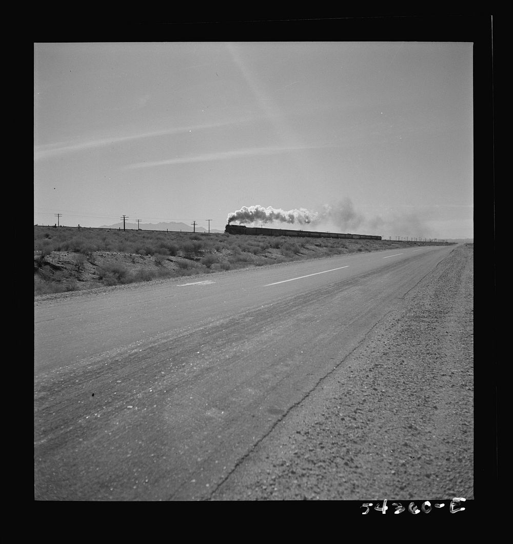 Kingman (vicinity), Arizona. A transcontinental train passing close to the tungsten recovery plant where the ore from the…
