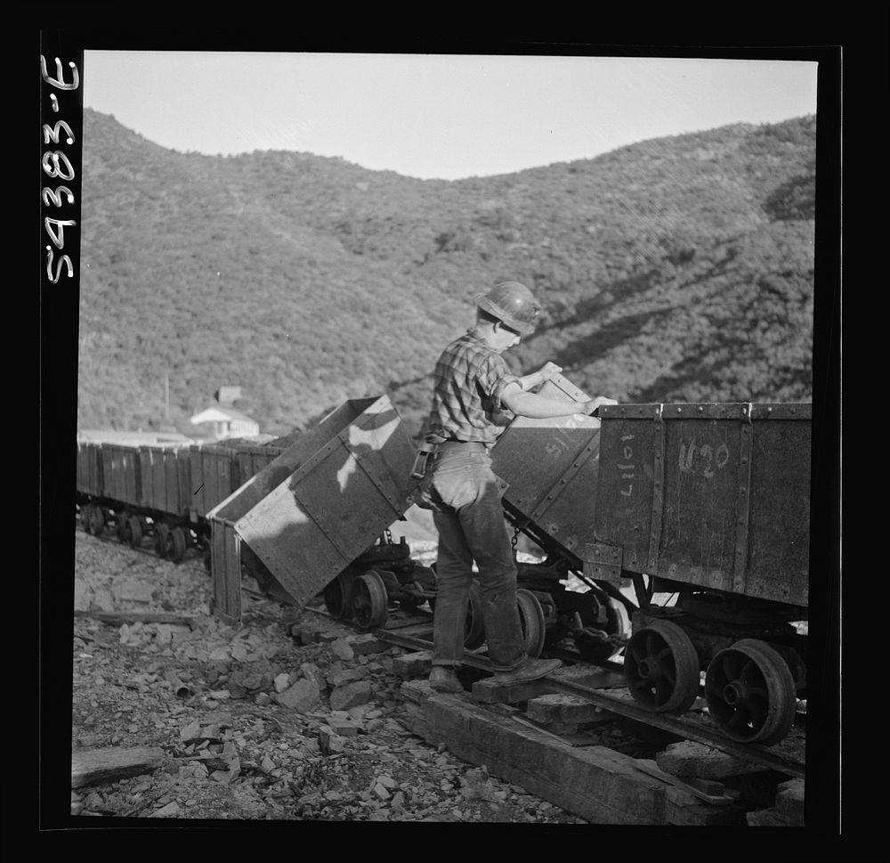 Kingman (vicinity), Arizona. A workman detaching a train of mine cars that have been hauling tungsten ore from the Boriana…