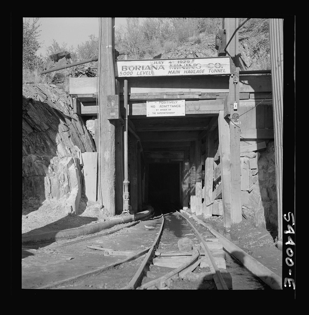 [Untitled photo, possibly related to: Kingman (vicinity), Arizona. A miner going toward a train of mine cars at the entrance…
