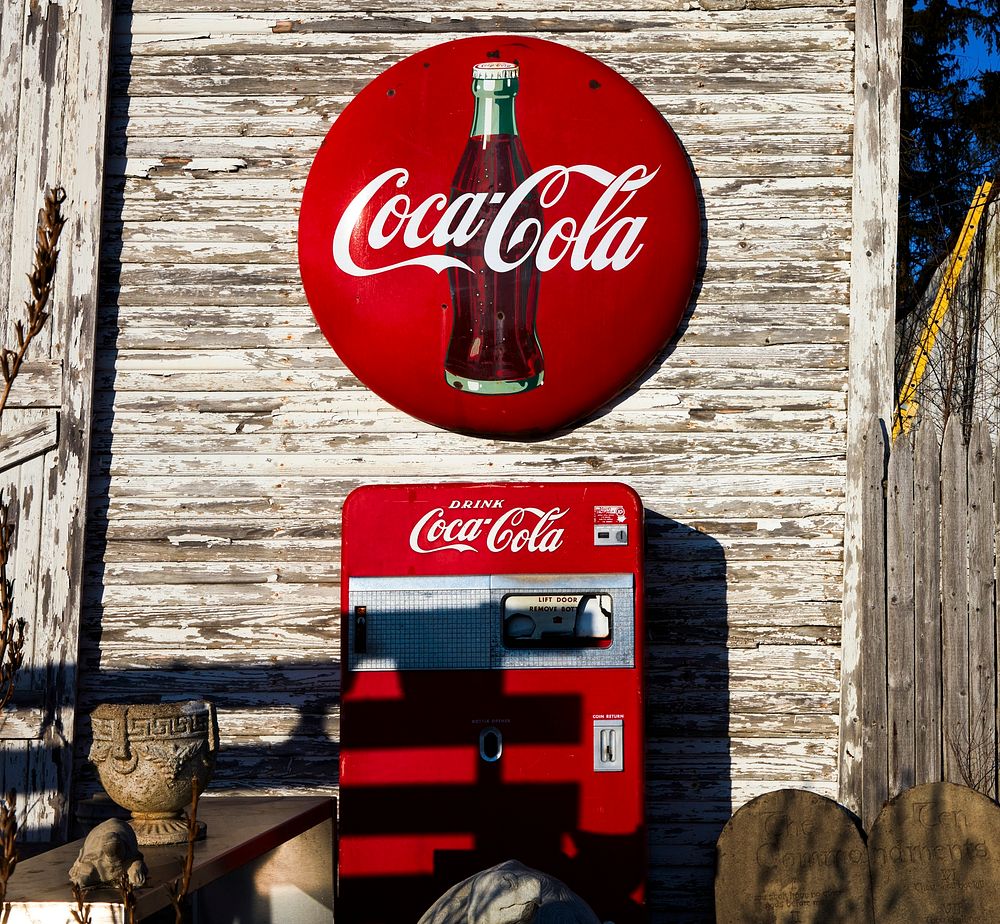 A vintage Coca-Cola sign and Coke machine outside the John E. Piedt & Sons Antique Store in Benton Harbor, Michigan.…