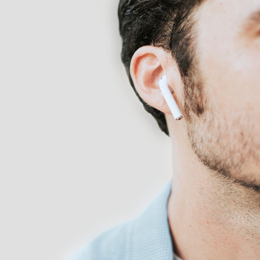 American man listening to music on wireless earphones closeup