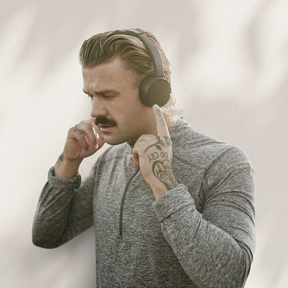 Handsome man wearing wireless headphones remixed media with shadow