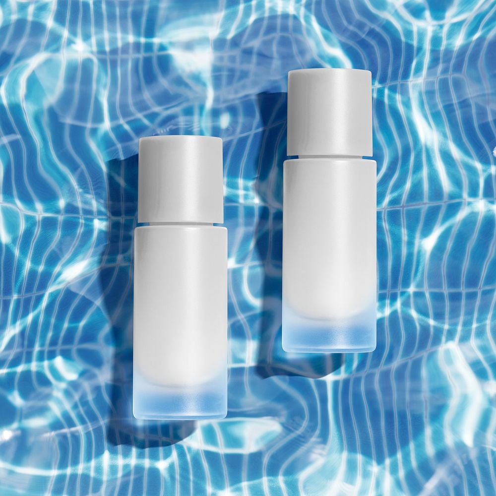 Cosmetic bottles on transparent water and light reflection background 