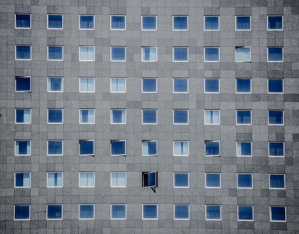 A regular arrangement of square windows in a gray tiled facade. Original public domain image from Wikimedia Commons