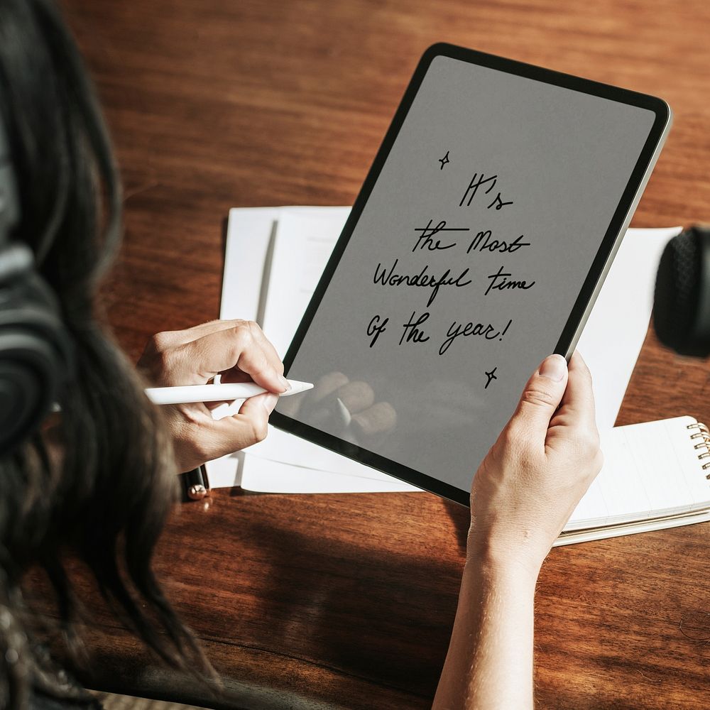 Designer drawing holiday greetings typography on tablet