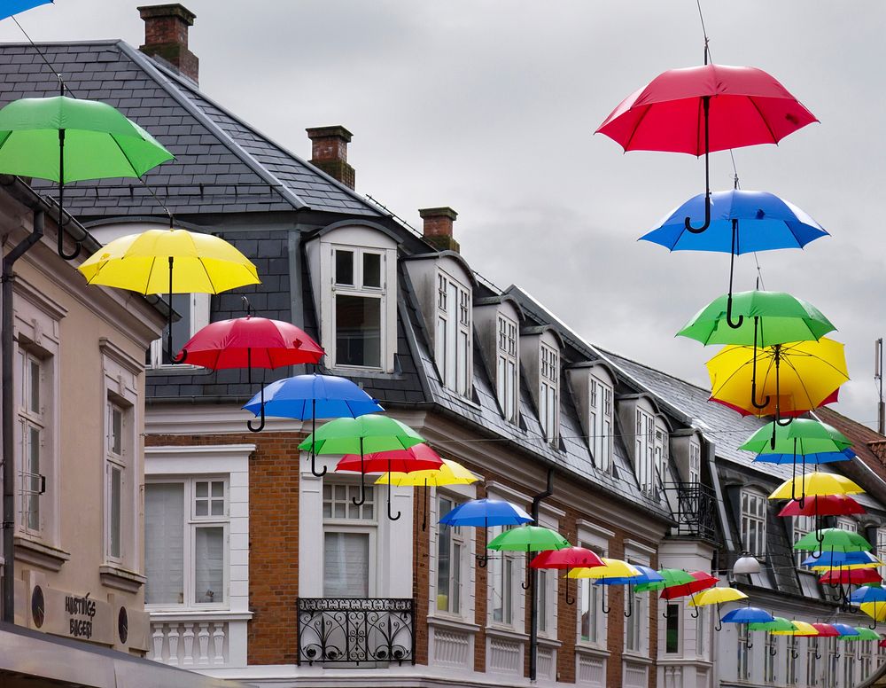 Umbrellas of various colours hanging over Vestergade, Viborg, Denmark. The photo was taken during heavy rain. It was…