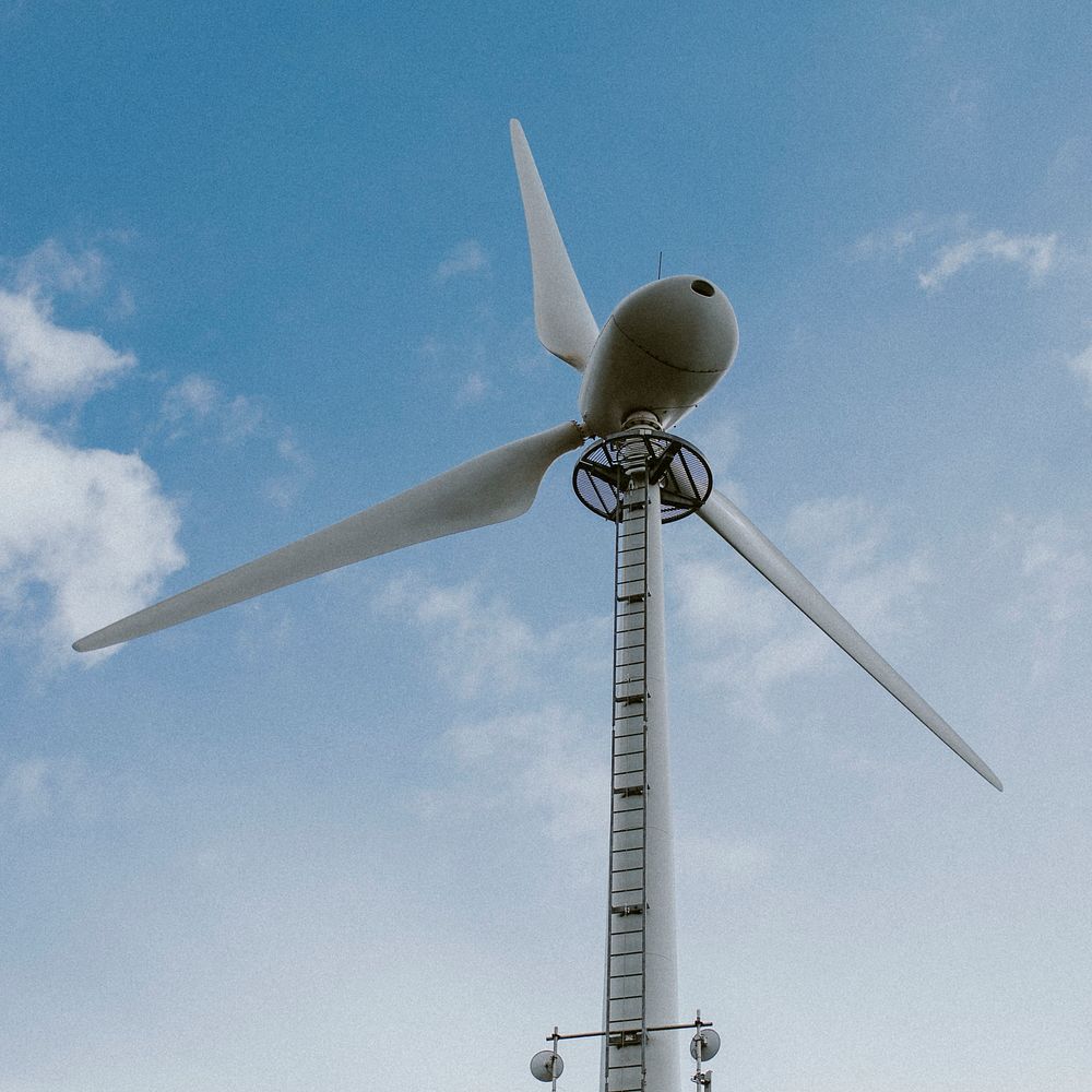 Wind turbine under blue sky renewable energy environmental campaign