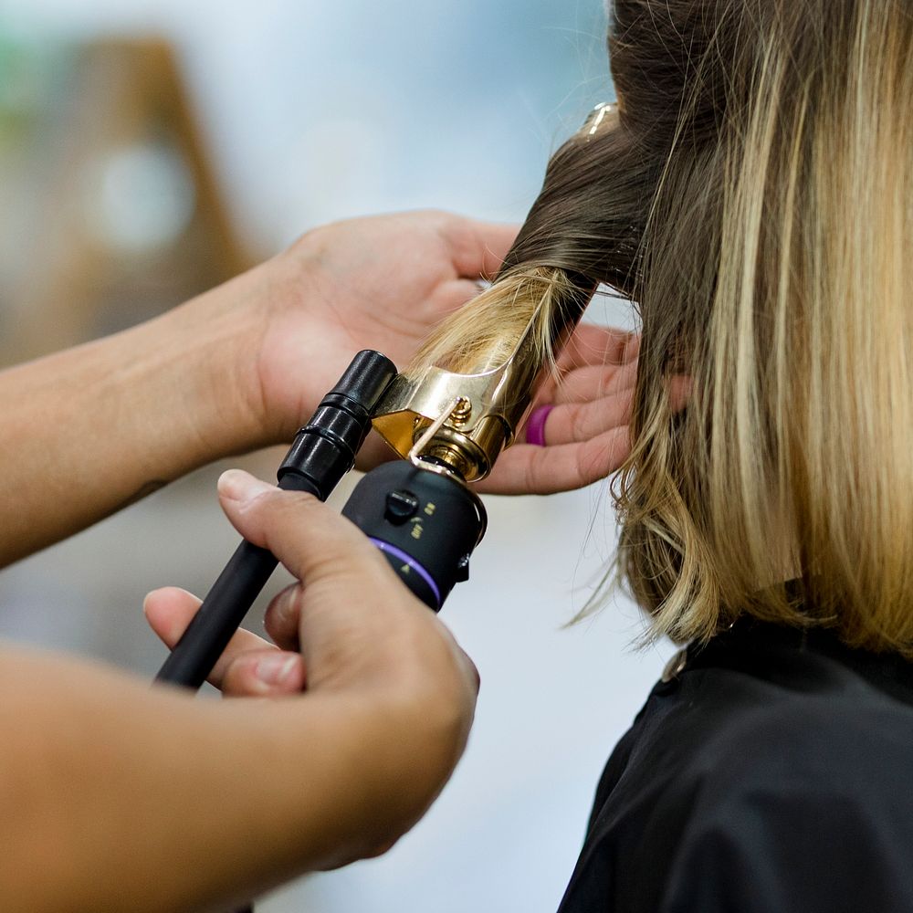 Woman getting her hair curled at a beauty salon 