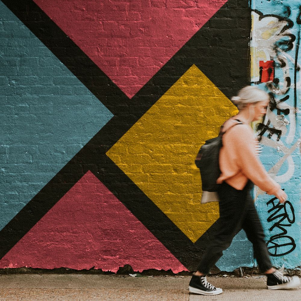 Woman walking past street art mural 